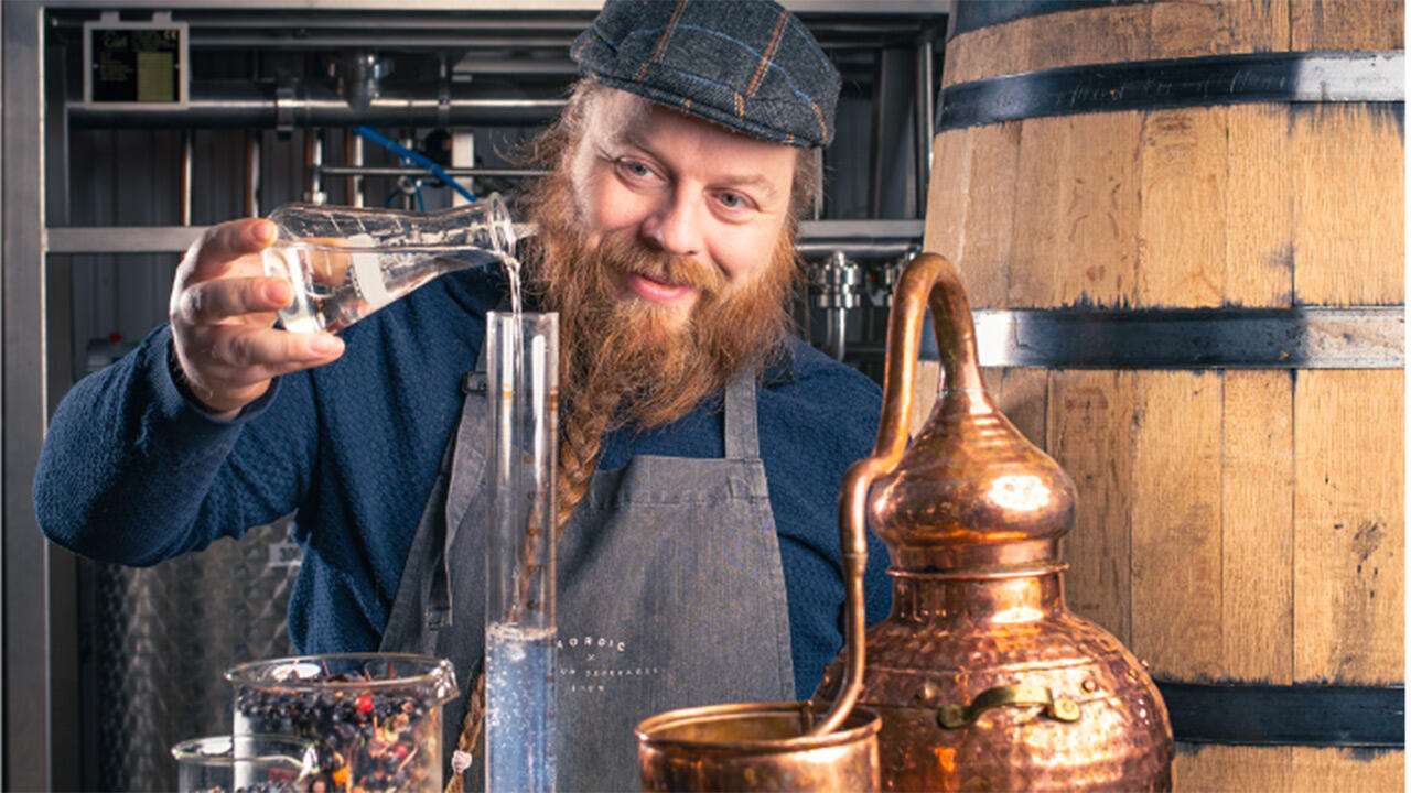 Photo of Master Distiller Asko Ryynänen transferring a clear liquid in his distillery