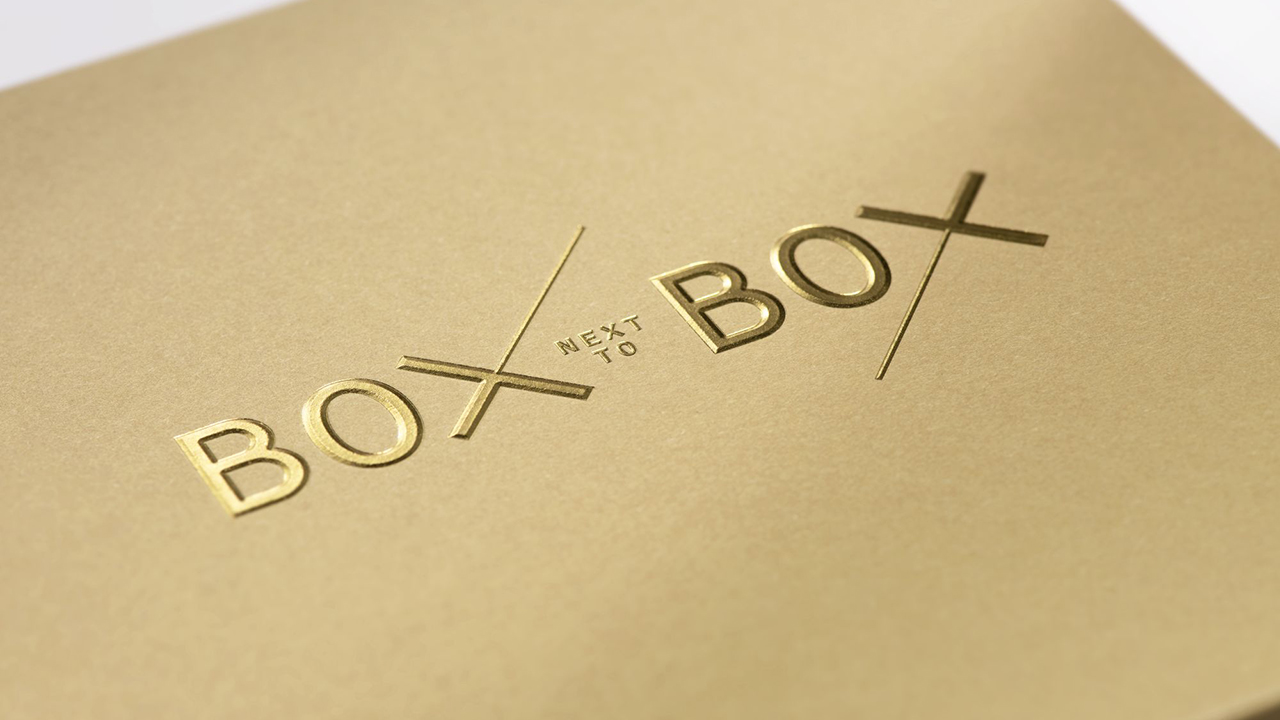 Deckel-Detail einer Karton-Verpackung mit goldenen, heißgeprägten Lettern