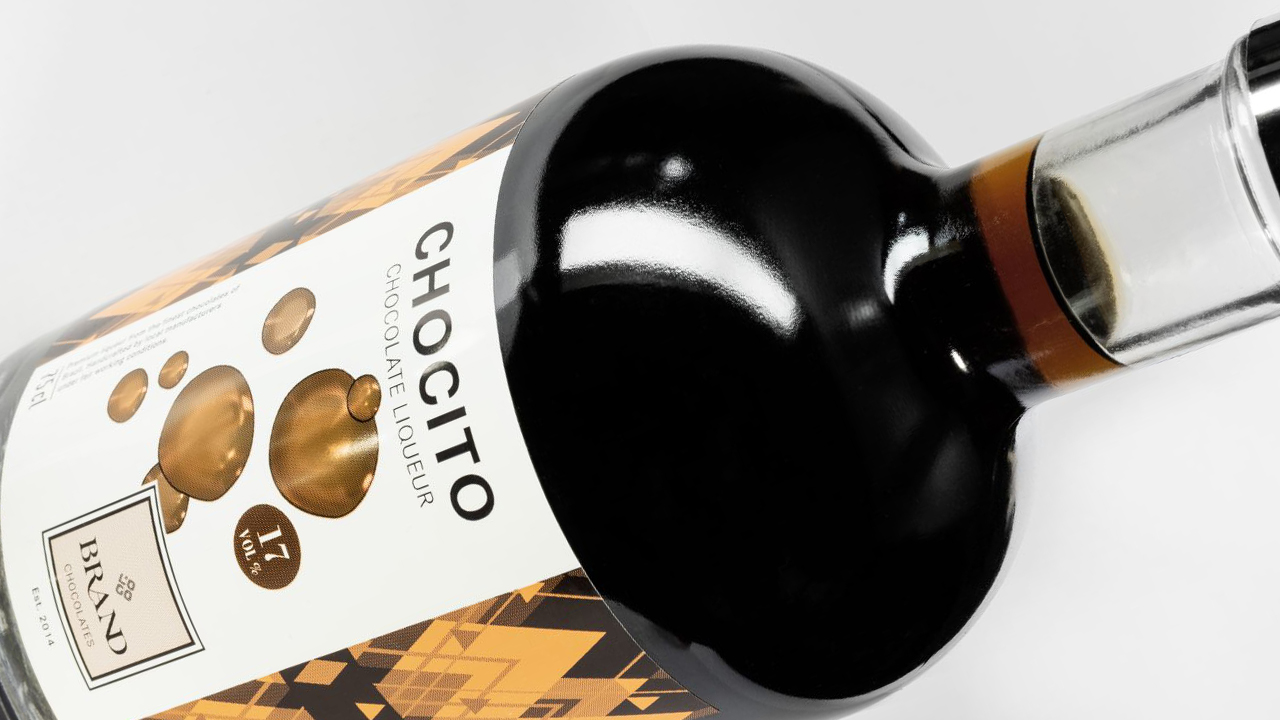 Nahaufnahme einer Flasche mit goldenem und schwarzem Etikettendesign und 3D-Blaseneffekten