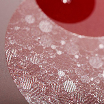 Detailansicht, rote Heißpräge-Veredelung mit Kreismuster, leichter Perlmuttglanz